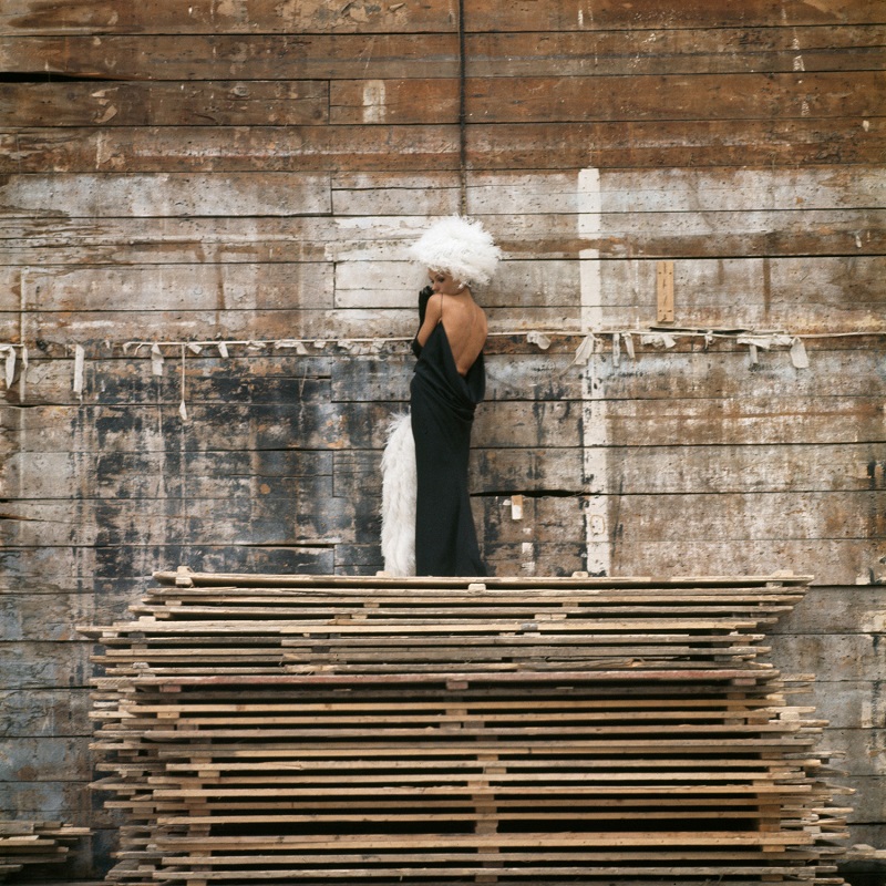 In Paris for the Paris collections, Milton and Joe Eula thought it would be a fine twist to use Tammy as one of the chosen models. As she was there for pleasure, Tammy was delighted and took some magnificent photographs. Here's Tammy in a slinky black dress and feather-lined cape and hat looking fabulous on top of a pile of lumber against a wooden wall.